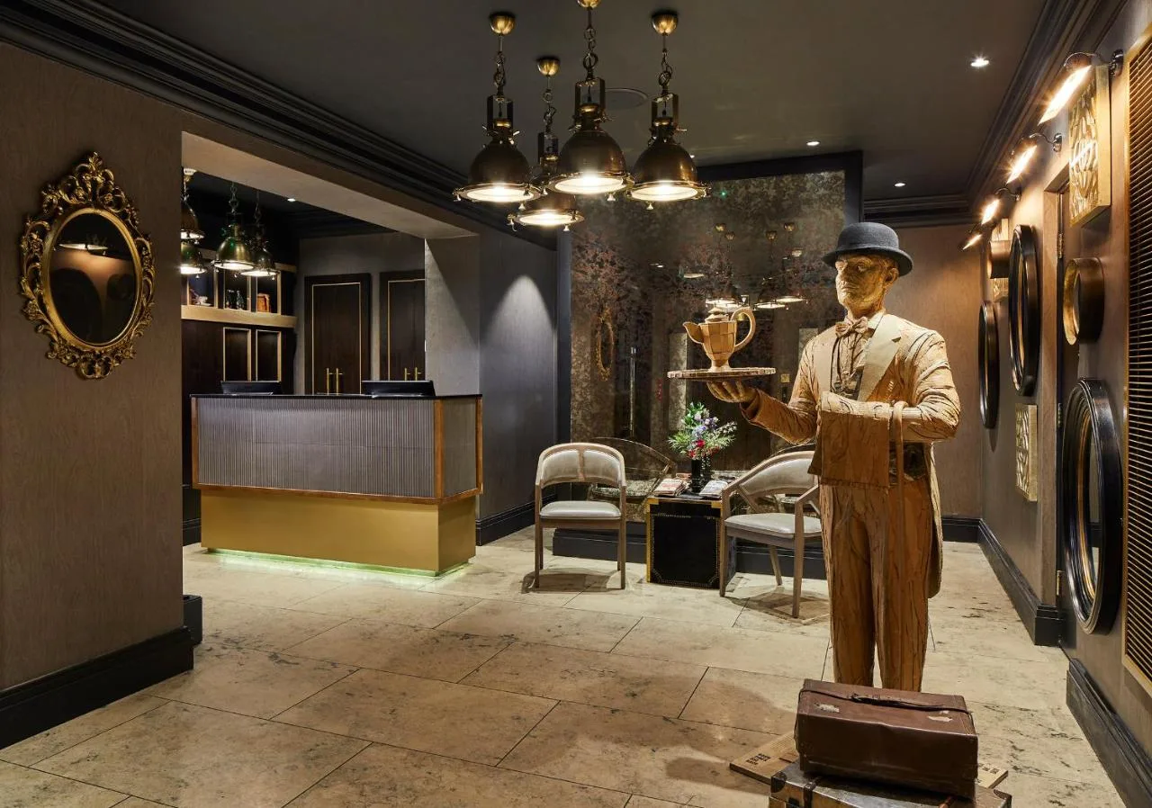 a statue of a man holding a wine glass at The Rex - formerly Hotel Gotham in Manchester